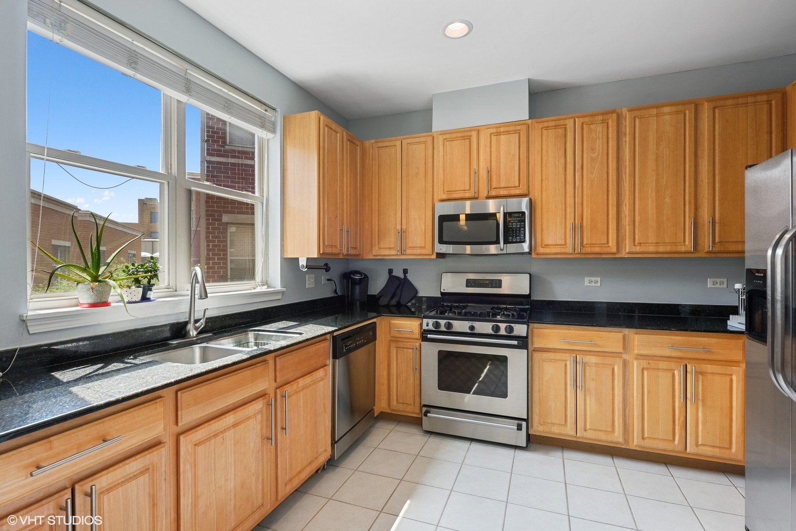 1344 North Burling Street Chicago, IL 60642 - Photo 5 of 21 a kitchen with stainless steel appliances granite countertop white cabinets granite counter tops and a window