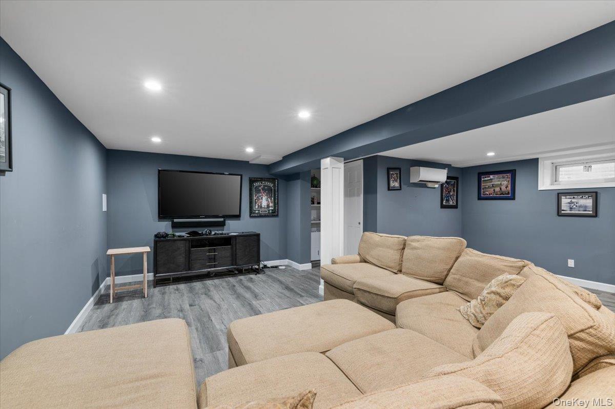 6 Apex Road Melville, NY 11747 - Photo 32 of 50 a living room with furniture and a flat screen tv