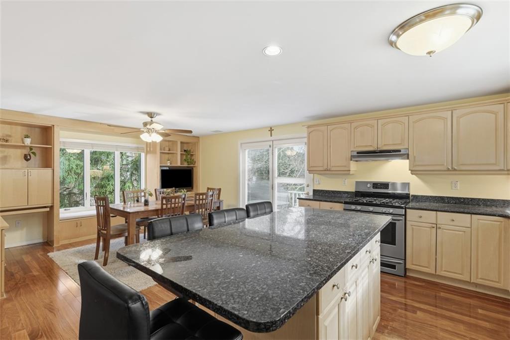 126 Leon Road Pittsburgh, PA 15220 - Photo 15 of 50 a kitchen with stainless steel appliances granite countertop a stove top oven a sink dishwasher and white cabinets with wooden floor
