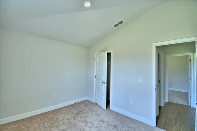an empty room with closet and windows