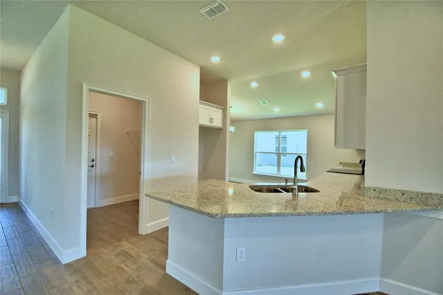 a kitchen with stainless steel appliances granite countertop a sink stove and cabinets