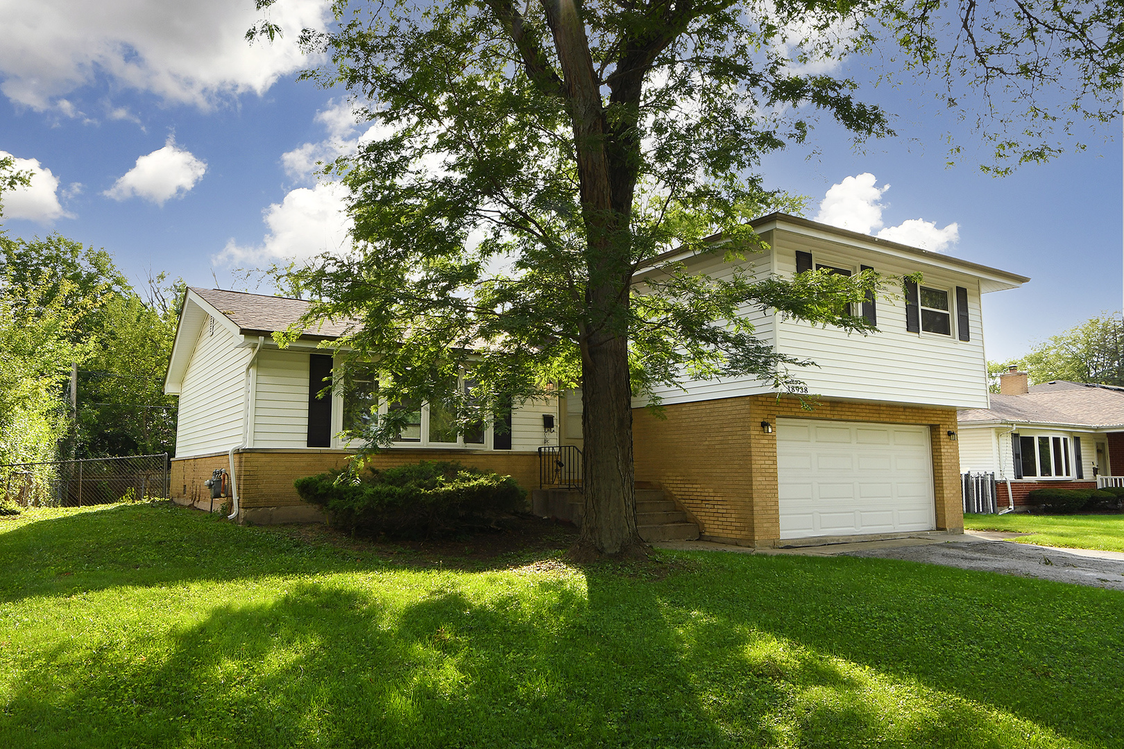 18938 Jonathan Lane Homewood, IL 60430 - Photo 1 of 33 a view of a white house with a big yard and large tree