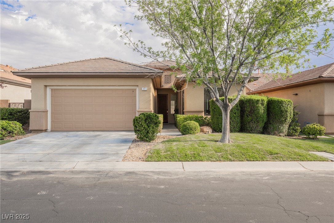 17 Caprington Road Henderson, NV 89052 - Photo 1 of 34 View of front facade featuring stucco siding, driveway, a tile roof, a garage, and a front lawn