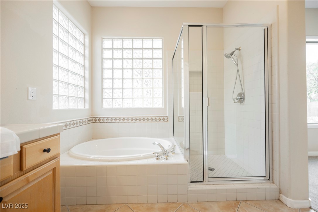 17 Caprington Road Henderson, NV 89052 - Photo 16 of 34 Bathroom with a garden tub, a stall shower, tile patterned floors, and vanity