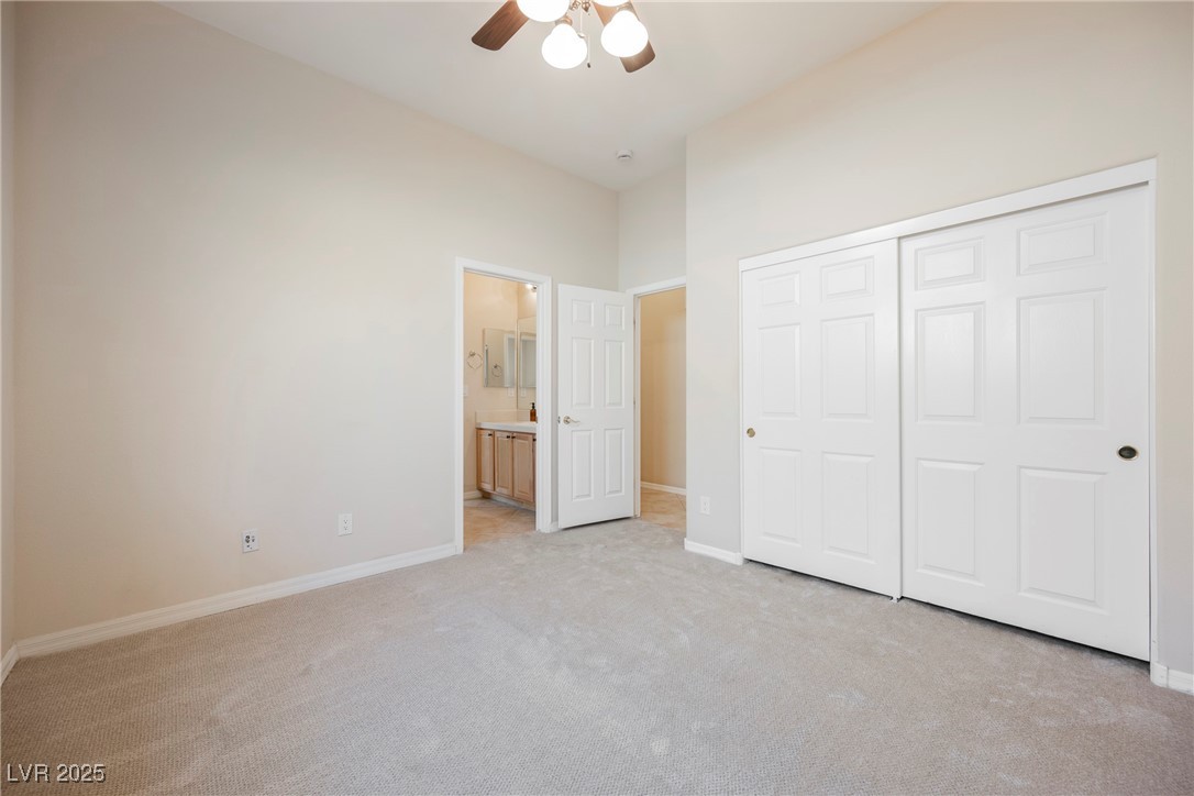 17 Caprington Road Henderson, NV 89052 - Photo 20 of 34 Unfurnished bedroom featuring light carpet, a closet, ensuite bathroom, and ceiling fan