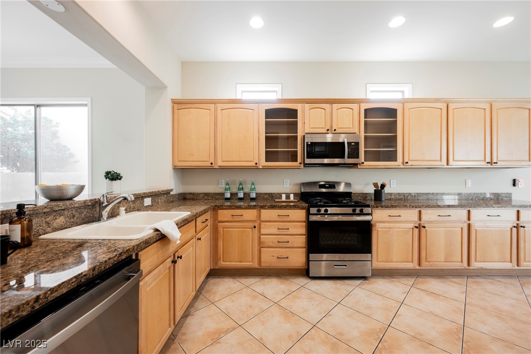 17 Caprington Road Henderson, NV 89052 - Photo 3 of 34 Kitchen featuring light brown cabinets, appliances with stainless steel finishes, light tile patterned flooring, glass insert cabinets, and recessed lighting
