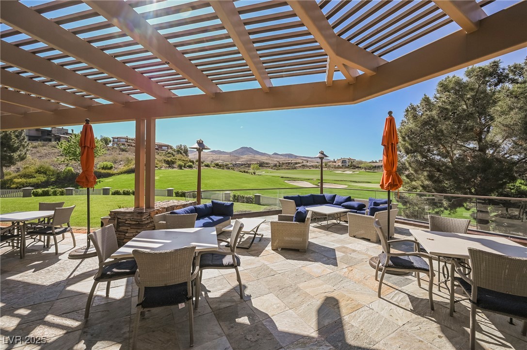 17 Caprington Road Henderson, NV 89052 - Photo 31 of 34 View of patio with outdoor dining area, outdoor lounge area, golf course view, a pergola, and a mountain view