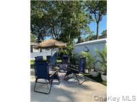 1661 Old Country Road Riverhead, NY 11901 - Photo 2 of 12 a view of patio with table and chairs under an umbrella