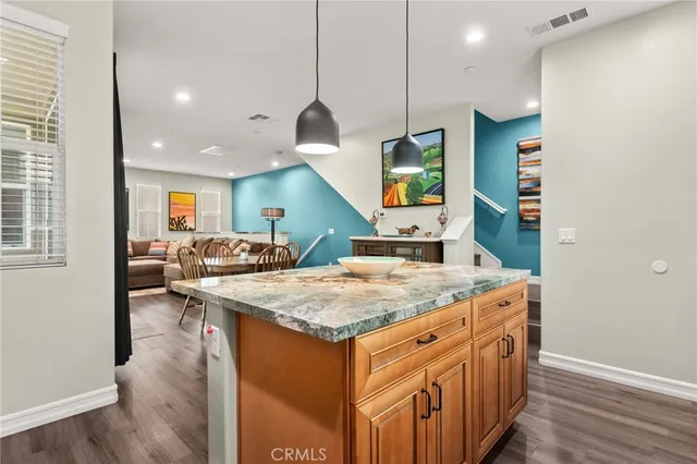 a kitchen with stainless steel appliances granite countertop a kitchen island a stove and a sink
