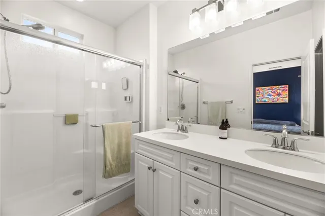 a bathroom with a double vanity sink mirror and shower