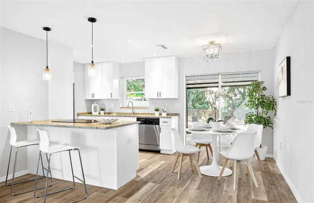 a kitchen with a sink a stove and chairs