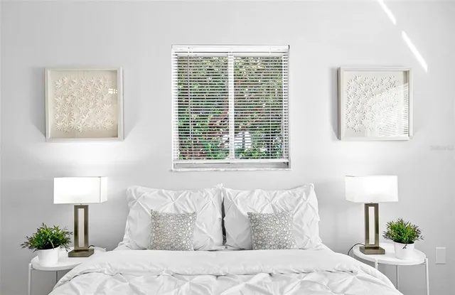 a large bed sitting in a bedroom next to a lamp