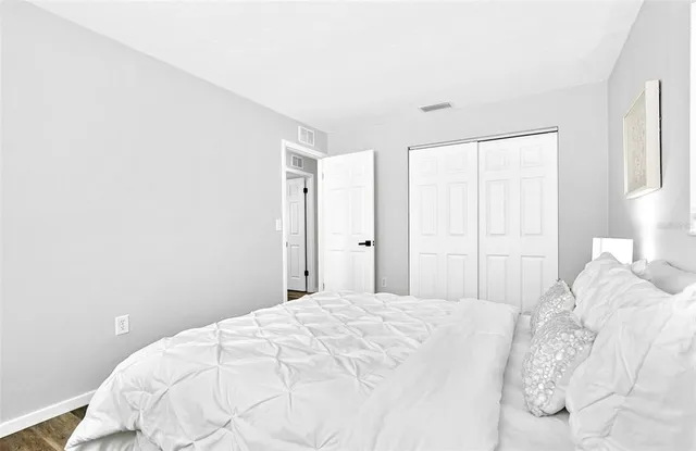 a bedroom with a white bed and a white cabinet