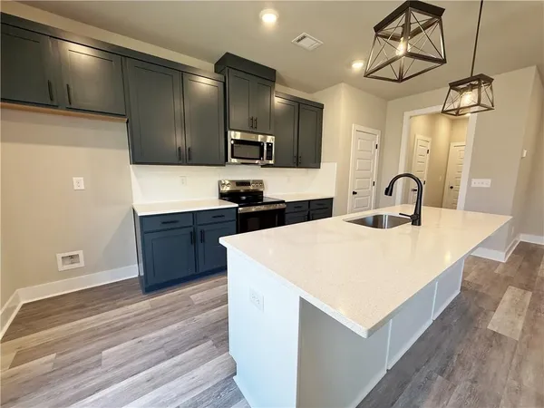 a large kitchen with a sink a counter space and appliances