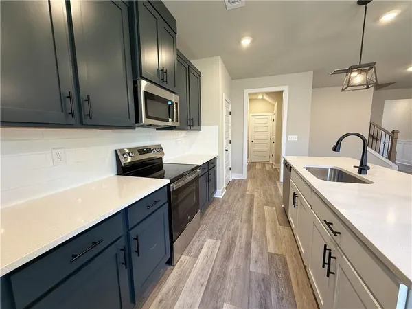 a kitchen with a sink stainless steel appliances a counter space and cabinets