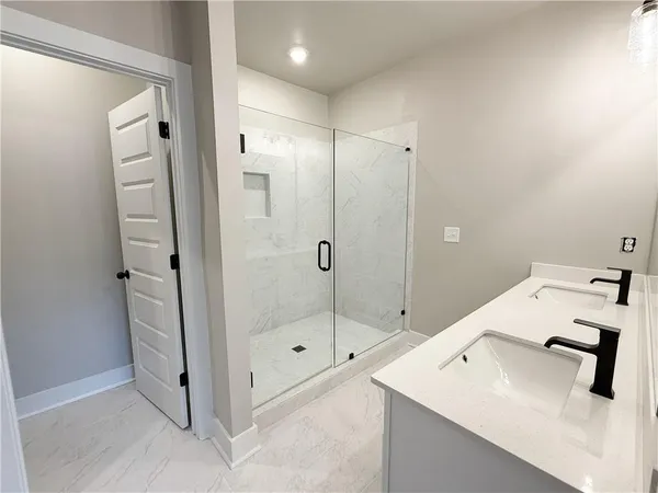 a bathroom with a sink a shower and mirror