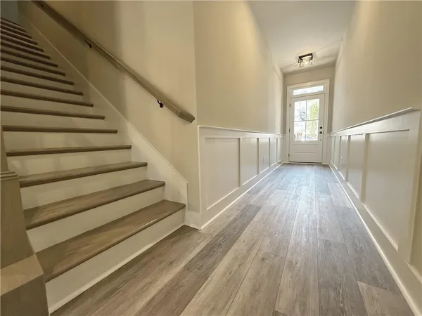 a view of a hallway with wooden floor and entryway