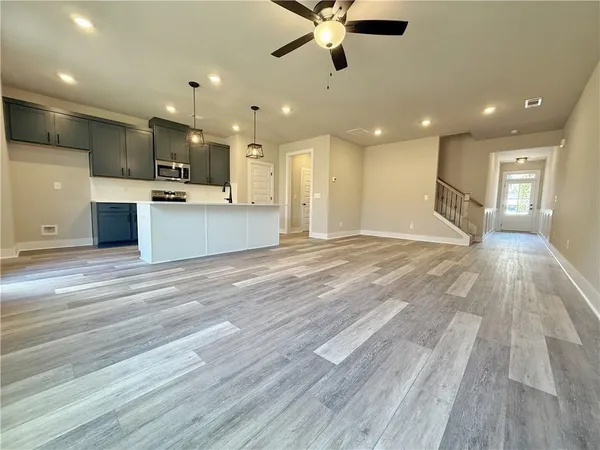 a view of kitchen with kitchen island stainless steel appliances refrigerator stove microwave and cabinets