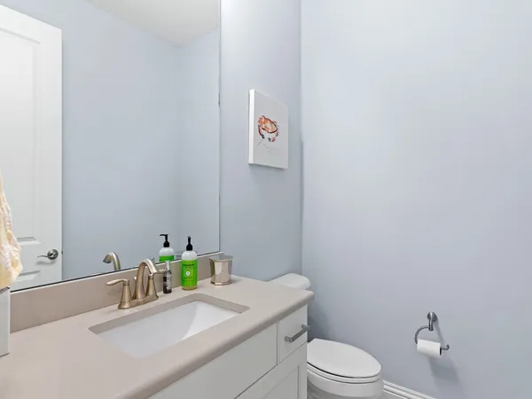 a bathroom with a sink vanity mirror and toilet