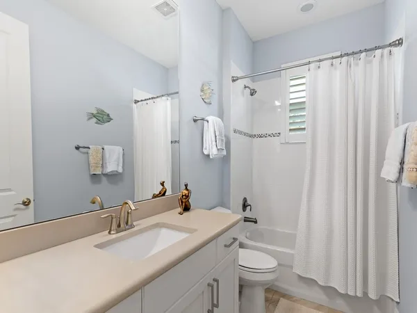 a bathroom with a granite countertop sink a toilet and a mirror