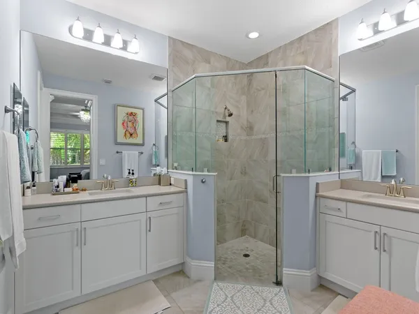 a bathroom with a double vanity sink mirror and shower