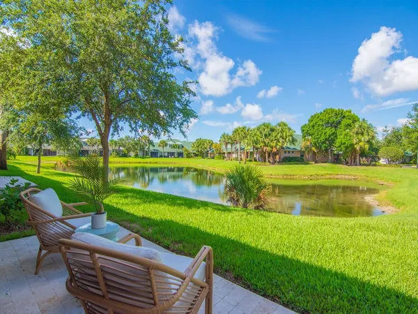 a view of a lake with couches and a big yard