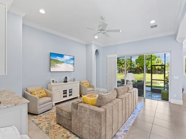 a living room with furniture kitchen view and a chandelier