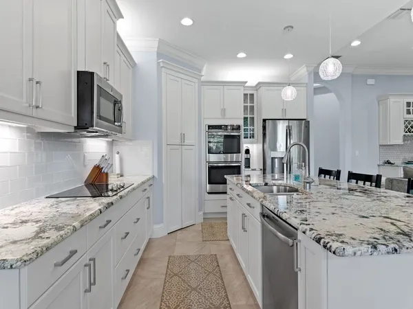 a kitchen with stainless steel appliances granite countertop a sink stove and refrigerator