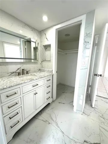 a bathroom with a granite countertop sink mirror and