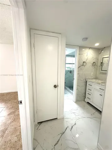a view of a sink and a refrigerator in a kitchen