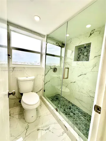 a bathroom with a toilet and a shower
