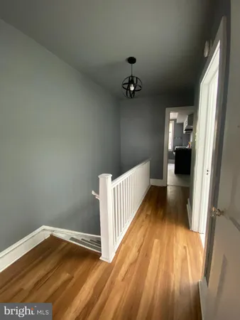 a view of a room with wooden floor and white walls