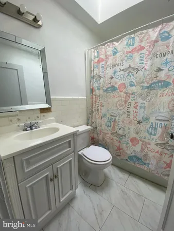 a bathroom with a granite countertop toilet sink and mirror