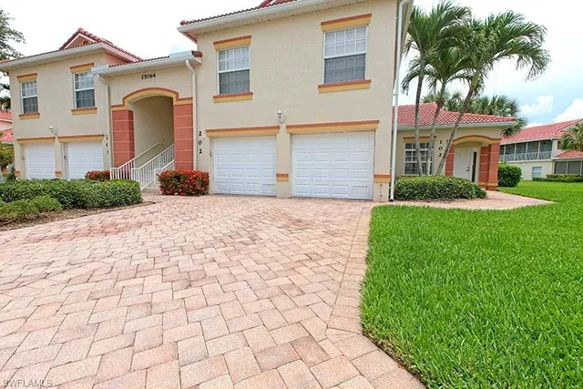 a front view of a house with a yard and potted plants