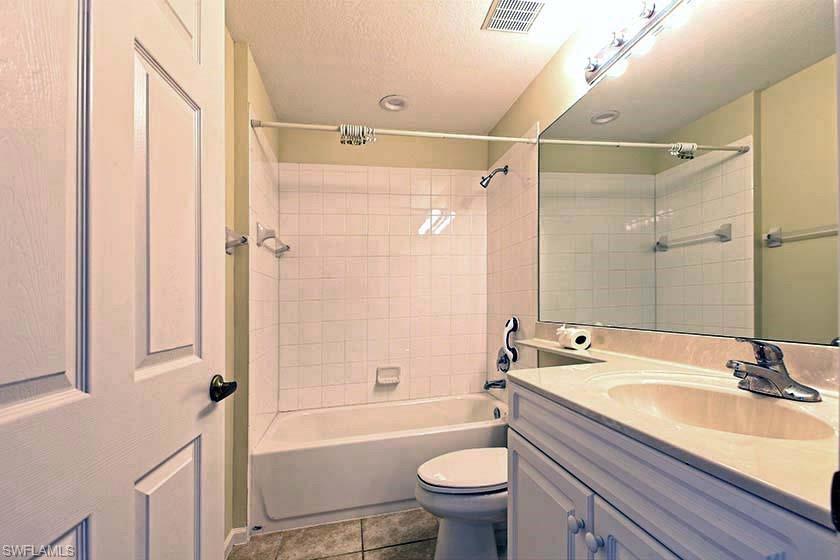 25064 Peacock Lane, Unit 102 Naples, FL 34114 - Photo 11 of 21 a bathroom with a granite countertop sink toilet and shower