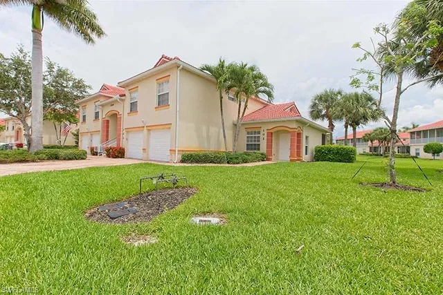 a front view of a house with a yard and trees