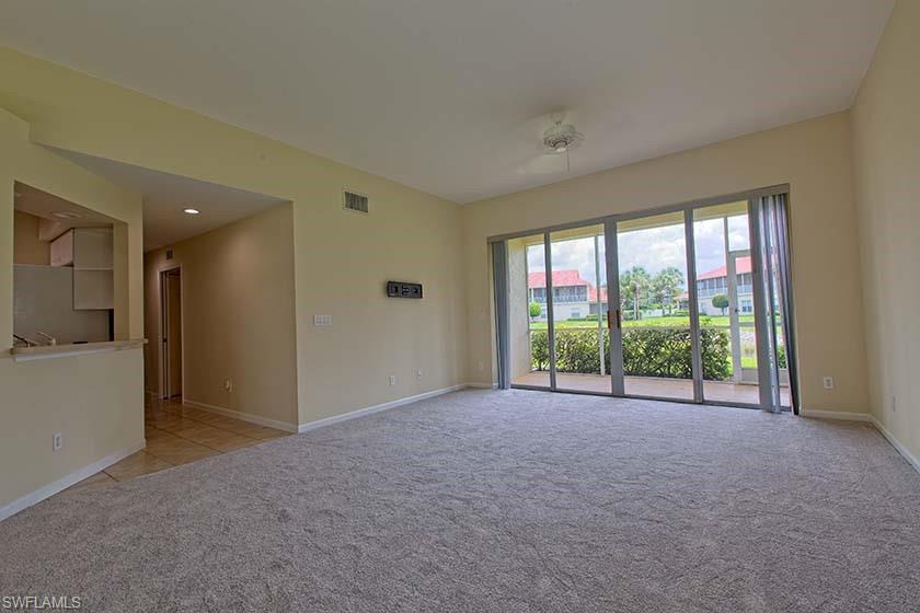 25064 Peacock Lane, Unit 102 Naples, FL 34114 - Photo 4 of 21 a view of an empty room with a sliding door
