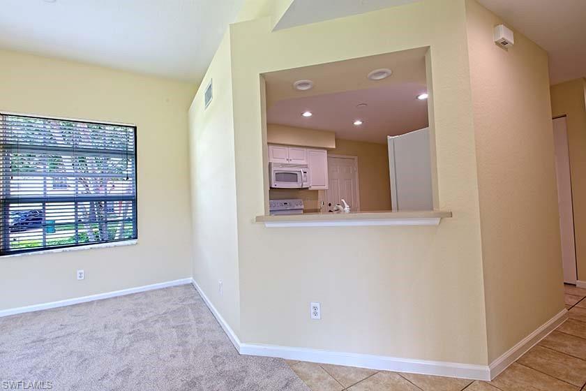 25064 Peacock Lane, Unit 102 Naples, FL 34114 - Photo 7 of 21 a view of a hallway with wooden floor and a large window
