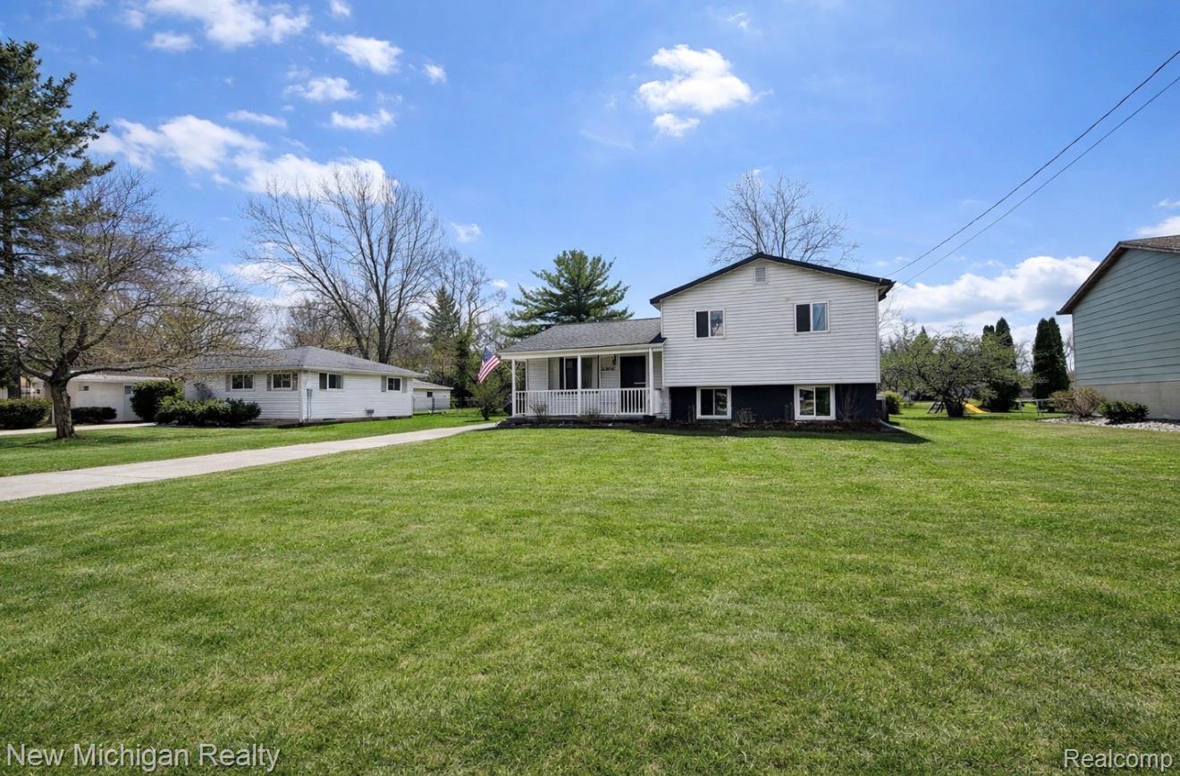 1054 Ransom Drive Flint, MI 48507 - Photo 1 of 27 Tri-level home featuring a porch and a front yard