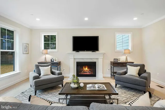 a living room with furniture a flat screen tv and a fireplace