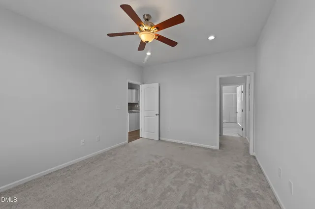 an empty room with closet and ceiling fan