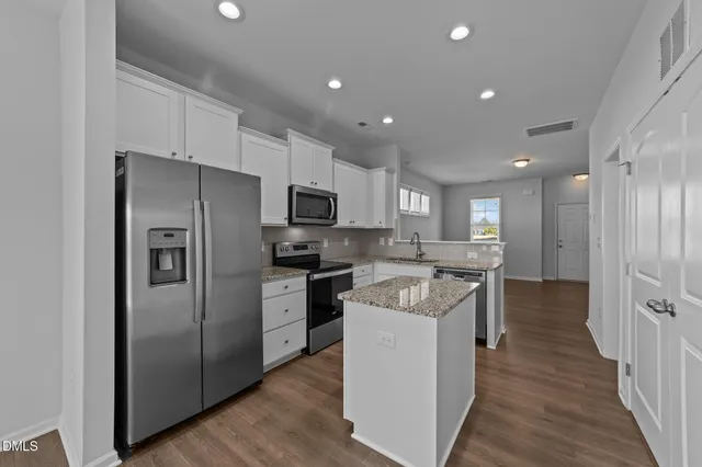 a kitchen with a refrigerator a sink and a microwave