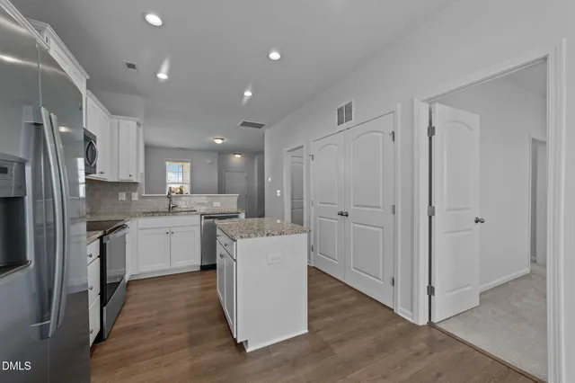 a kitchen with white cabinets and stainless steel appliances