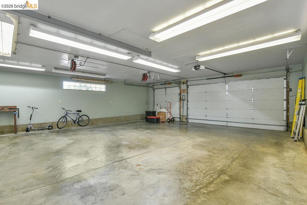 325 South 2nd Street Rio Vista, CA 94571 - Photo 26 of 33 Spacious two-car garage featuring a concrete floor, two sectional garage doors with automatic openers, and overhead fluorescent lighting