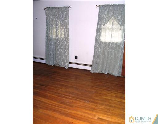 3 Ellmyer Road Edison, NJ 08820 - Photo 11 of 18 a view of an empty room with wooden floor and a window