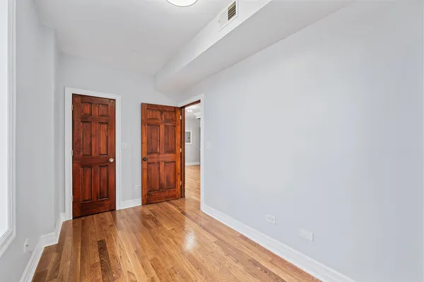 a view of empty room with wooden floor