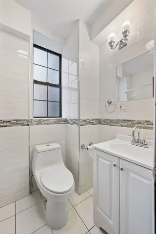 a bathroom with a granite countertop toilet sink and mirror