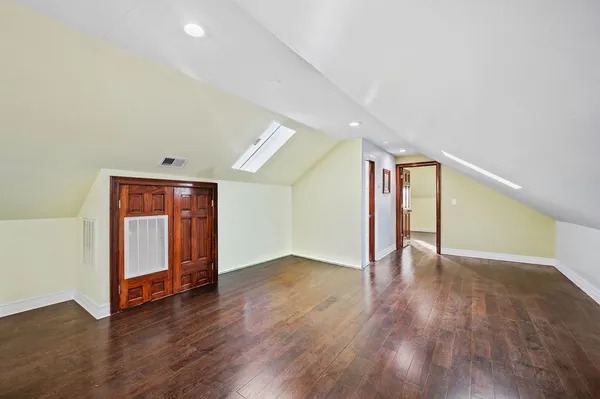 a view of an empty room with wooden floor and closet