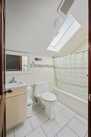 a bathroom with a toilet a sink a mirror and shower