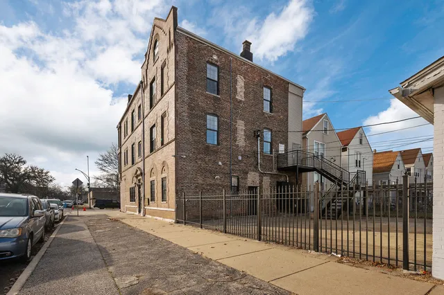 a view of a brick building next to a yard